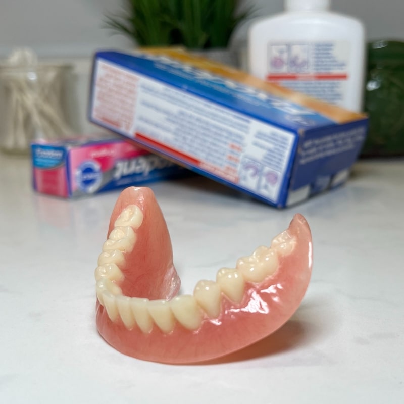 lower denture with adhesives in background