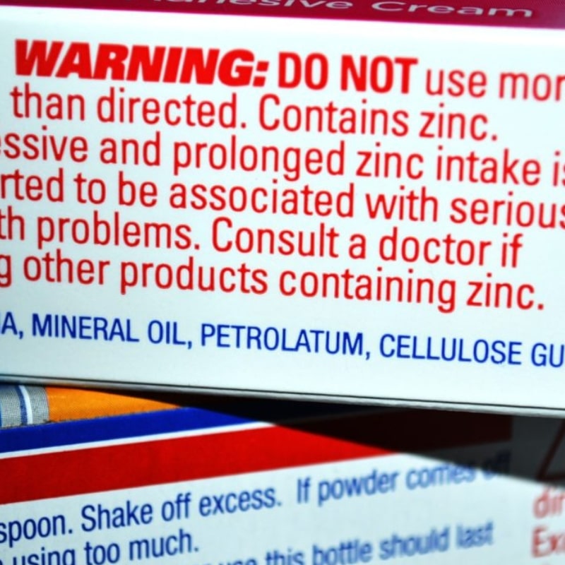 close up of zinc warnings on denture adhesive packaging